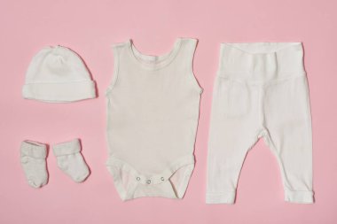 Pembe bir arka plan üzerinde bebek moda kavramı. Cap, gömlek, pantolon ve çorap.