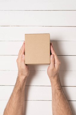 Küçük paket erkek elinde. Üstten Görünüm. Arka plan beyaz masaya