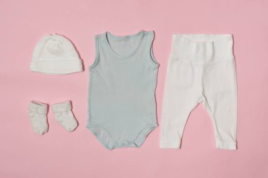 Pembe bir arka plan üzerinde bebek moda kavramı. Cap, gömlek, pantolon ve çorap.