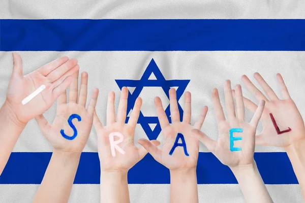 Izrael felirat a gyermekek kezébe, a háttérben a hullámzó zászlót, Izrael — Stock Fotó
