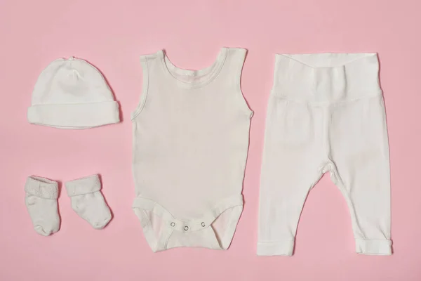 Concepto de moda de bebé sobre un fondo rosa. Gorra, body, pantalones y calcetines . —  Fotos de Stock