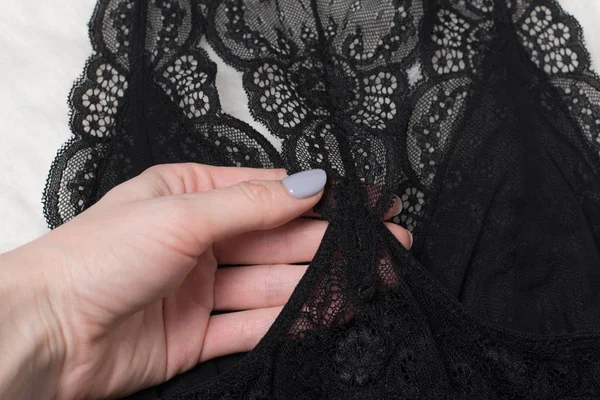 Detalles de lencería de encaje negro en mano femenina. Concepto de moda. De cerca. — Foto de Stock