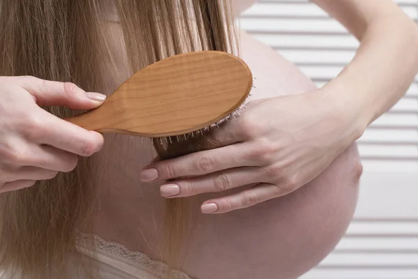 Mujer embarazada peinándose el pelo largo. Primer plano. Concepto de salud —  Fotos de Stock