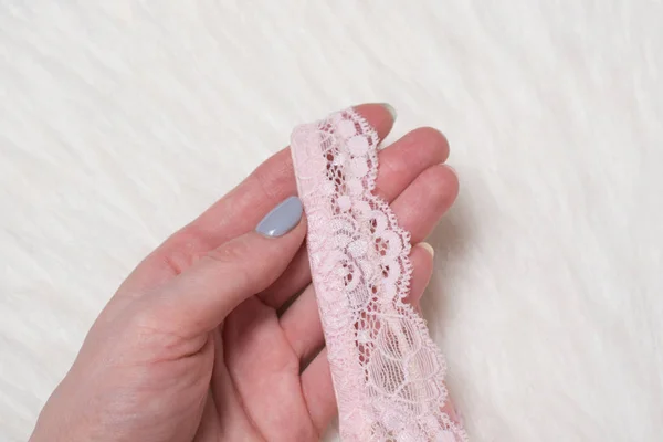Soutien-gorge en dentelle rose à la main féminine. Pose plate. Concept lingerie mode . — Photo