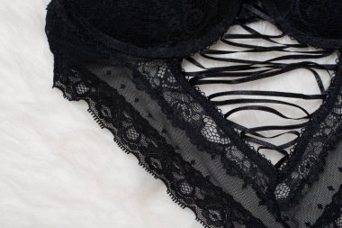 Beyaz kürk üzerinde bağlama ile siyah korsaj. Düz yatıyordu. Moda iç çamaşırı kavramı.