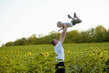 Babası oğlunun bir yeşil ayçiçekleri alanı gökyüzü kadar atar.