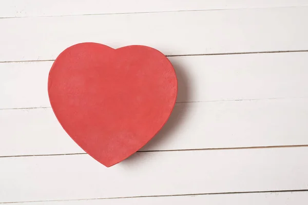 Caja en forma de corazón rojo sobre mesa de madera blanca — Foto de Stock