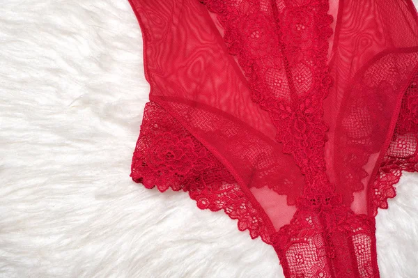 Details of red lace body on white fur. Fashion lingerie concept