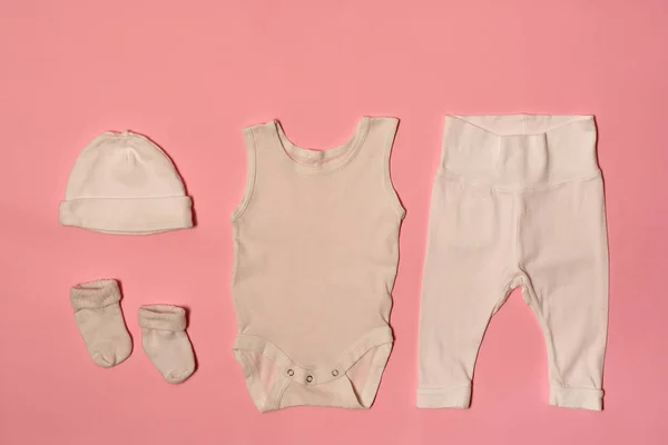 Concepto de moda de bebé sobre un fondo rosa. Gorra, body, pantalones y calcetines . —  Fotos de Stock