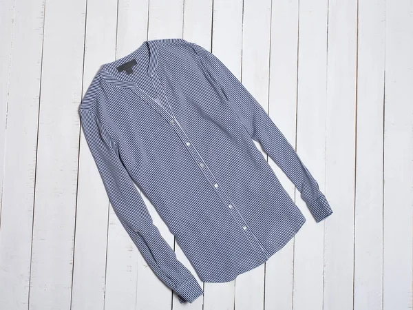 Голубая полосатая хлопковая рубашка на белом деревянном фоне. Концепция моды . — стоковое фото