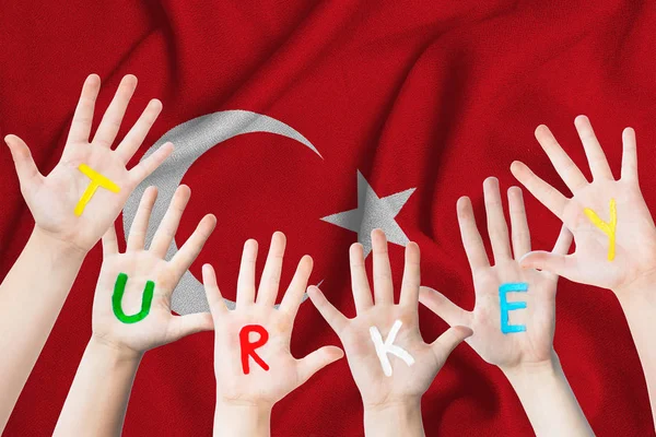 Туреччина напис на руках дітей на тлі розмахував прапором Туреччини — стокове фото