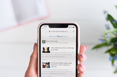 Kharkiv, Ukrayna - 10 Nisan 2019: Kadın ekranda medicalnewstoday.com site ile Apple iphone X tutar.