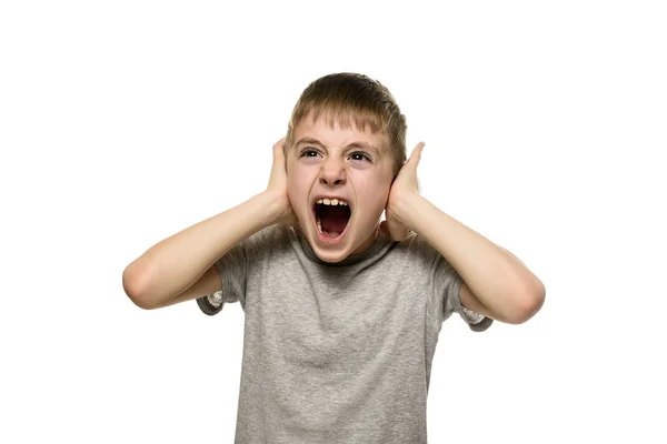 Boy closed his ears with his hands and shouts furiously. Naughty schoolboy. Isolate — Stock Photo, Image