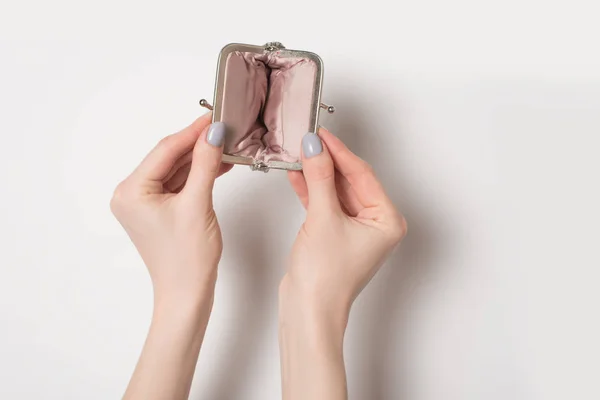 Порожній відкритий металевий гаманець у жіночих руках на світлому фоні — стокове фото