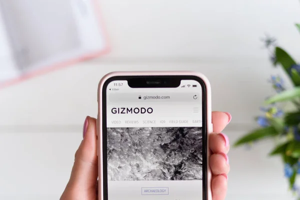 KHARKIV, UCRÂNIA - 10 de abril de 2019: Mulher segura Apple iPhone X com site gizmodo.com na tela . — Fotografia de Stock