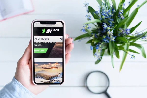 ハリコフ, ウクライナ - 4月 10, 2019: 画面上のdeviantart.comサイトと女性の手でアップルのiPhone X. — ストック写真