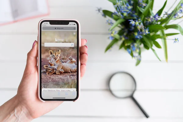 KHARKIV, UCRANIA - 10 de abril de 2019: Mujer sostiene Apple iPhone X con el sitio Bing.com en la pantalla. Página de búsqueda —  Fotos de Stock