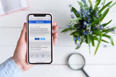 Kharkiv, Ukrayna - 10 Nisan 2019: Kadın ekranda Answers.com site ile Apple iphone X tutar.
