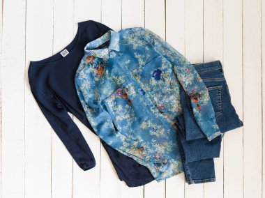 Kharkov, Ukrayna - 27 Nisan 2019: Giyim moda konsepti. Beyaz ahşap arka plan üzerinde iki mavi gömlek ve kot pantolon. Üstte görüntü