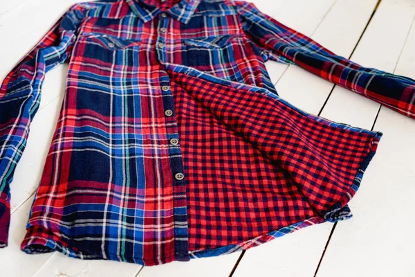 Η ιδέα για τα ρούχα. Λεπτομέρειες από καρό πουκάμισο σε ξύλινο φόντο. Κορυφαία προβολή — Φωτογραφία Αρχείου