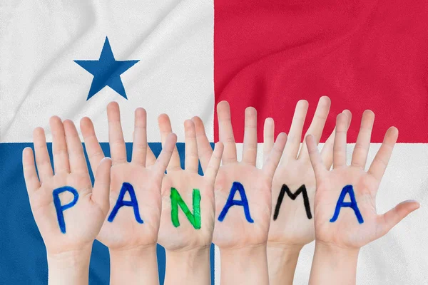 Напис Панама на руках дітей на тлі розмахуючи прапором Панами — стокове фото