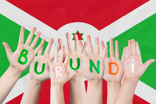 Inscripción Burundi en las manos de los niños sobre el fondo de una bandera ondeante del Burundi — Foto de Stock