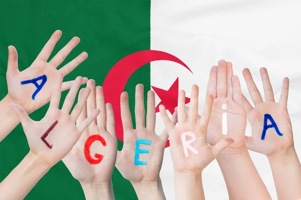 Inscripción Argelia en las manos de los niños sobre el fondo de una bandera ondeante de Argelia — Foto de Stock