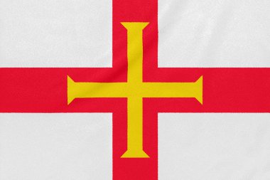 Dokulu kumaş üzerinde Guernsey bayrağı. Vatansever sembolü