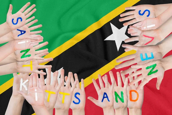 Felirat Saint Kitts és Nevis a gyermekek ellen a háttérben egy hullámzó zászlót a Saint Kitts és Nevis — Stock Fotó