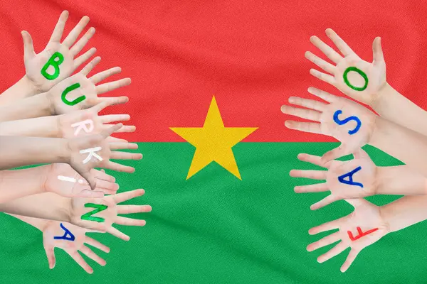 Επιγραφή Μπουρκίνα Φάσο στα χέρια των παιδιών με φόντο τη σημαία της Μπουρκίνα Φάσο — Φωτογραφία Αρχείου