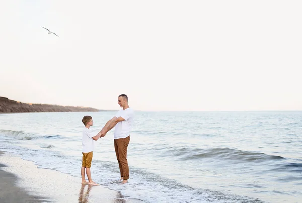 Padre e hijo divirtiéndose en la costa. Vacaciones familiares. Amistad — Foto de Stock