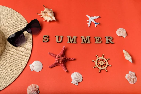 字夏天从木字母。贝壳、飞机、帽子的一部分、太阳镜和方向盘。活珊瑚背景。平躺。旅行理念 — 图库照片