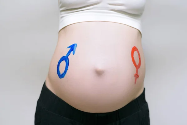 Symbole płci sporządzone na ciężarnej kobiecej brzuchu. Koncepcja w ciąży. Zbliżenie — Zdjęcie stockowe