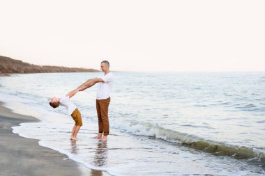 Baba ve oğul deniz kıyısında eğleniyor. Aile tatili. Dostluk