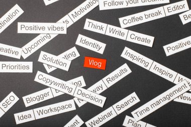 Kırmızı bir arka plan üzerinde kesme kağıt yazıt vlog, koyu bir arka plan üzerinde diğer yazıtlar ile çevrili. Word bulut kavramı.