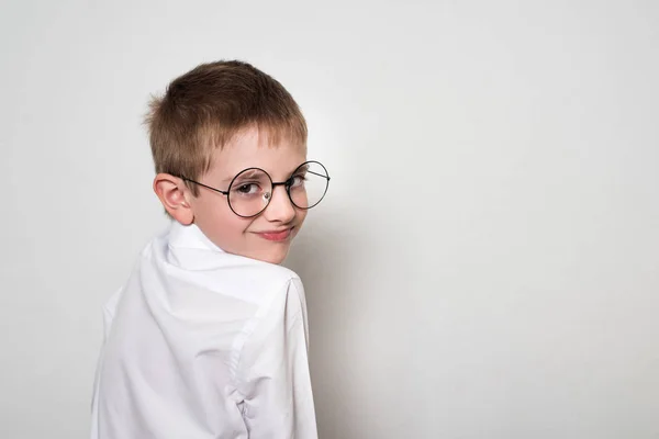 Portret uśmiechniętego przystojnego chłopca w dużych okrągłych okularach. Białe tło. — Zdjęcie stockowe