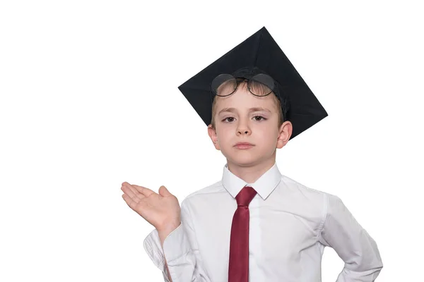 Niño con un sombrero académico cuadrado y gafas sostiene su palma hacia arriba. Concepto escolar. Aislar —  Fotos de Stock