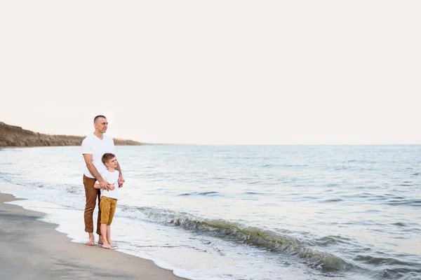 Padre e hijo se quedan en la costa del mar. Vacaciones familiares. Amistad — Foto de Stock