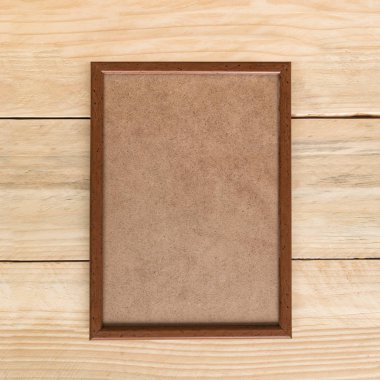 Açık kahverengi ahşap duvar üzerinde boş kahverengi ahşap fotoğraf çerçevesi. Alay etmek