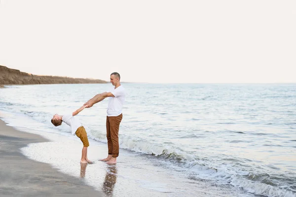 Ο πατέρας και ο γιος διασκεδάζουν στις ακτές της θάλασσας. Οικογενειακές διακοπές. Φιλία — Φωτογραφία Αρχείου