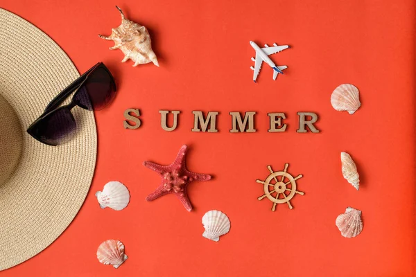 字夏天从木字母。贝壳、飞机、帽子的一部分、太阳镜和方向盘。活珊瑚背景。平躺。旅行理念 — 图库照片