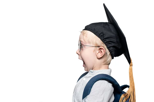 Portrait d'un garçon blond surpris dans des lunettes, un chapeau académique et un cartable. Concept de l'école. Isoler — Photo