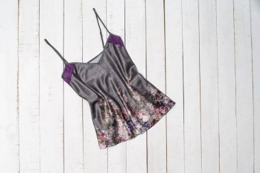 Kharkov, Ukrayna - 27 Nisan 2019: Gri saton t-shirt beyaz ahşap arka plan üzerinde çiçekler. Giyim konsepti. Düz yatıyordu