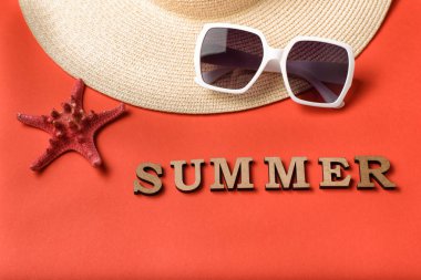 Kelime yaz ahşap harfler. Güneş gözlüğü, şapka ve yıldız balığı parçası. Canlı mercan geçmişi. Seyahat konsepti