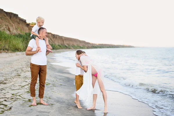 Familia de cuatro divirtiéndose en la orilla del mar. Padres y dos hijos. Familia amistosa feliz — Foto de Stock