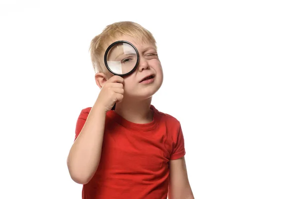 Niño rubio con una lupa en las manos. Pequeño explorador. Fondo blanco —  Fotos de Stock