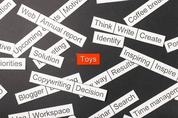 Corte los juguetes de inscripción de papel sobre un fondo rojo, rodeado de otras inscripciones sobre un fondo oscuro. Concepto nube de palabras . — Foto de Stock