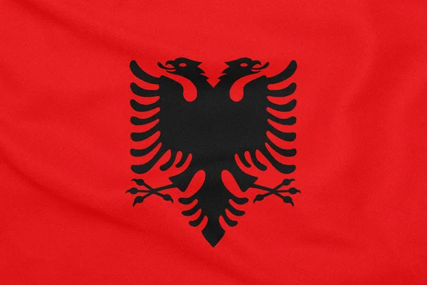 Flag af Albanien på tekstureret stof. Patriotisk symbol - Stock-foto