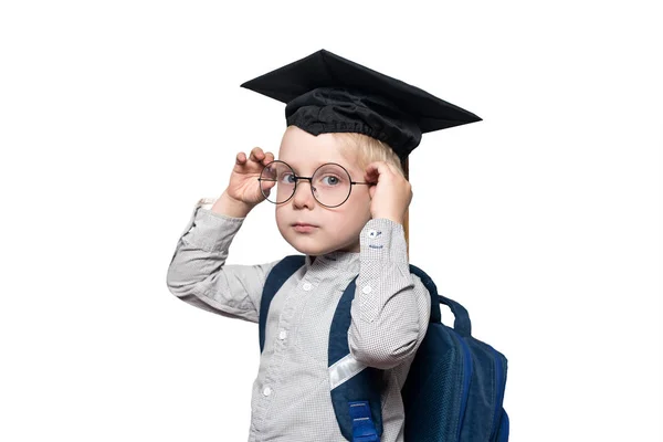 Portrait d'un garçon blond dans un chapeau académique et un cartable. Corrige les lunettes. Isoler. Concept scolaire — Photo