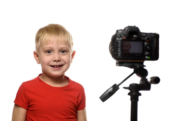 Усміхнений блондин перед об'єктивом камери. Маленький відео блогер. Білий фон — стокове фото